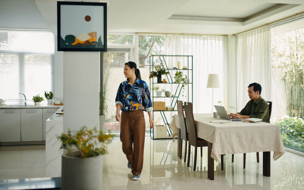 Pasangan di ruang makan terbuka dengan konsep open plan yang menggabungkan area dapur, ruang makan, dan ruang keluarga dalam satu ruang terintegrasi.