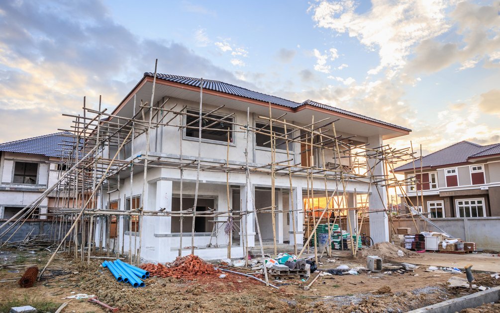 Proyek desain rumah renovasi dengan scaffolding bambu dan material bangunan di lokasi konstruksi residensial
