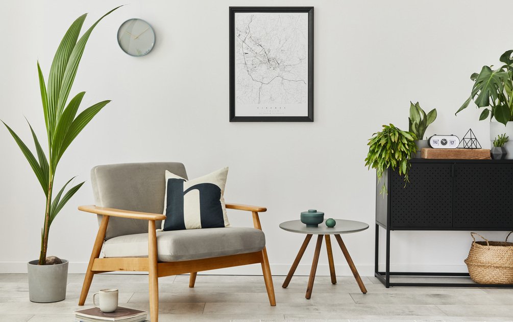 Ruang tamu modern hasil interior design profesional dengan kursi kayu, meja kopi bundar, dan dekorasi tanaman menggambarkan kualitas yang dipengaruhi harga interior design
