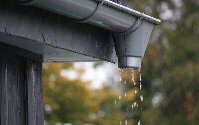 Ilustasi talang air yang mengalirkan air ke drainase sebagai tips merawat rumah
