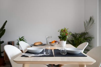 Ruang makan modern minimalis dengan meja kayu terang dan kursi ergonomis yang memberikan sirkulasi lega