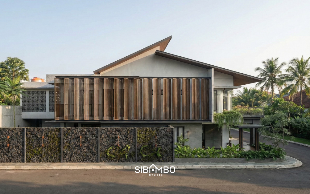 Fasad samping Bumi Sampur Daria dengan secondary skin kayu dan dinding batu pada rumah modern tropis Depok