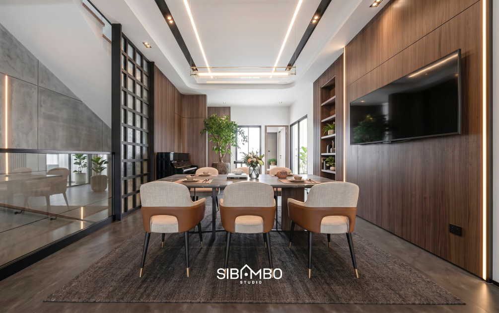 Ruang makan Casa Luminara dengan panel kayu dan partisi kaca pada rumah modern kontemporer Jakarta Selatan