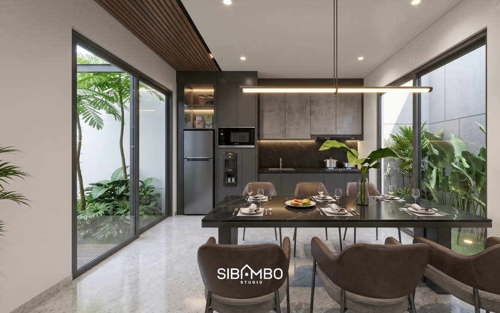Ruang makan dan dapur Dua Rona Residence dengan kabinet abu gelap dan taman kecil di kedua sisi